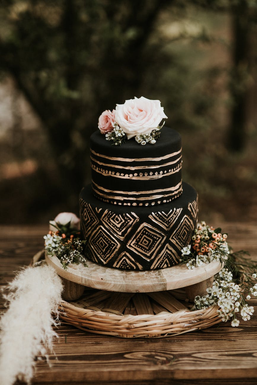 black round cake with gold details on brown wooden table